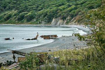 closed bay on a remote island with abandoned equipment and a sunken ship. Beach camping and a yacht...