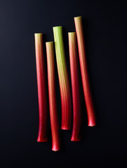 Rhubarb stalks on black background, from above