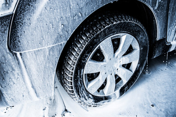 Washing car with soap. Close up clean car concept at car wash.