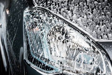 Obraz premium Washing car with soap. Close up clean car concept at car wash.