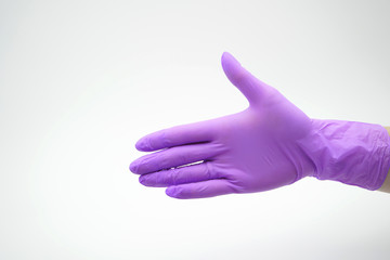 Medical, latex, nitrile glove on a white background stretches for a handshake.