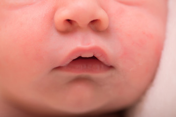 Portrait of newborn baby. Nose and lips close up. Concept of healthcare. Small lips and mouth in soft focus.