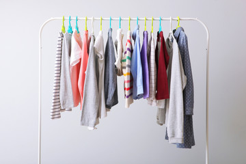 Children clothes on a rack on a light background. Children's clothing, children's stores.
