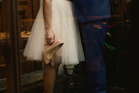 Woman Holing A Pare Of Pretty Shoes In The Rain.