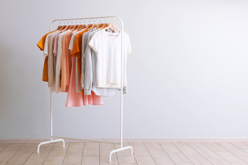 fashion clothes on a rack in a light background indoors. place for text - obrazy, fototapety, plakaty