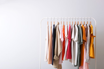 fashion clothes on a rack in a light background indoors. place for text