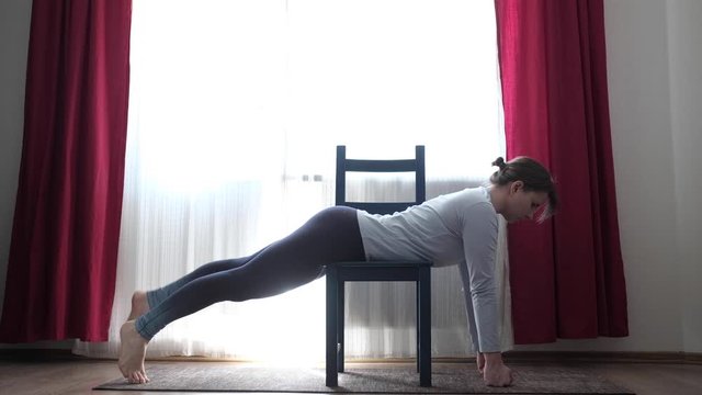 woman doing the Shalabhasana on exercise mat at home