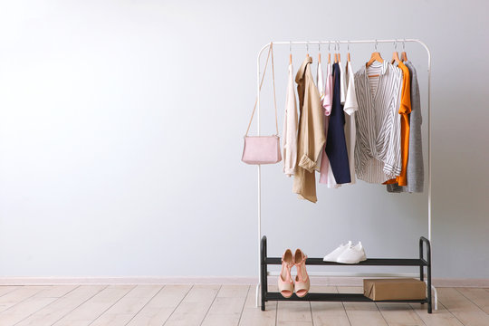 fashion clothes on a rack in a light background indoors. place for text - a rack with clothes and cl