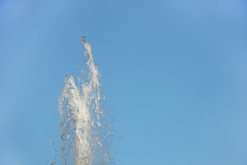 A stob of water striking up against a blue sky. Spray fountain in the sun. Delivery of drinking water to the city for the population. Irrigation of arid soil. Pure drinking water to quench your thirst