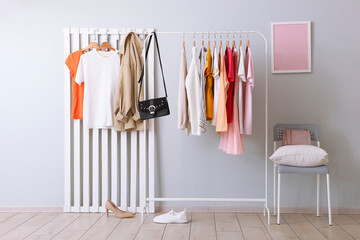 fashionable clothes on a rack in a bright interior of the wardrobe room