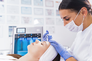 Lady is getting injection into her forehead