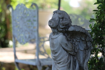 Little Cupid statue decorated in a natural garden