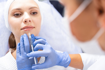 Caucasian female patient undergoing a beauty procedure - obrazy, fototapety, plakaty