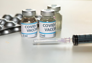 Coronavirus preventive drugs with vaccine bottles and injection syringe shot in selective focus