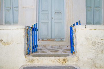 Beautiful traditional whitewashed facade of Greek house in small and narrow alley or street in...