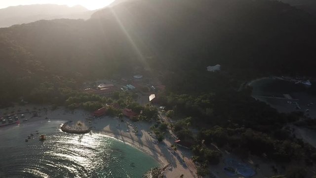 Golden rays of sun shine brightly above a tropical beach in the Caribbean