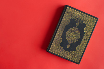 Quran on a plain burgundy background. Space for your text.