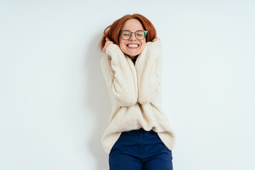 Cute young woman cuddling down into a warm sweater