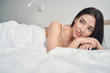 Peaceful young woman relaxing in her bedroom