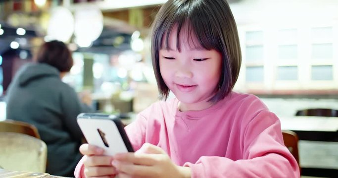 Asian girl play mobile game happily