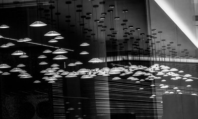 The UFOS.
Black and white picture of many lamps who looks like small ufos hanging from the ceiling of an office.
