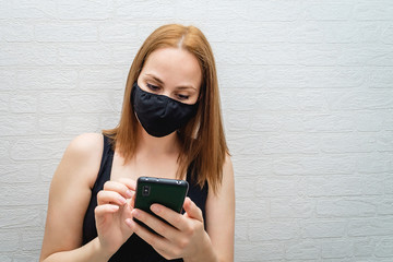 Fototapeta premium beautiful girl in a black medical mask calls the rescue service