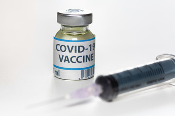 Vaccine bottle with injection syringe on white background shot with selective focus used as preventive drug for Coronavirus