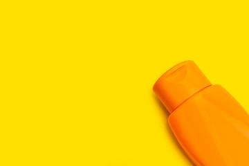 Crema solar sobre un fondo amarillo liso aislado y brillante. Vista superior. Copy space