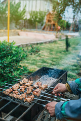 a man fries kebabs on the grill in his infield.