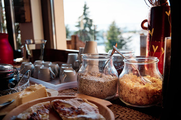 A breakfast buffet with cereal at a mountain cabin with stunning view during sunrise.
