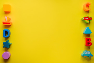 Top view on children s toys on a yellow background. Children's toys on the table. concept for advertising toys for children. Copy space children's toy.
