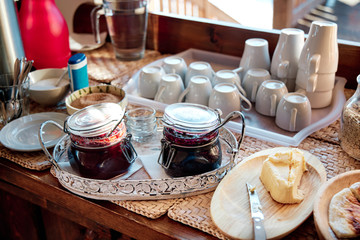 A breakfast buffet with homemade jams and butter at mountain cabin during sunrise.