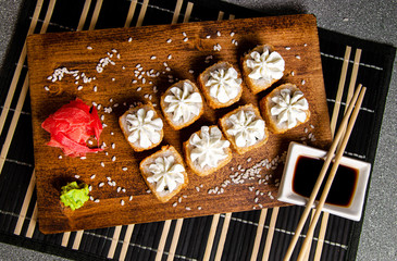 Baked rolls with a white hat
Wood background. White cup with sauce. Chinese chopsticks