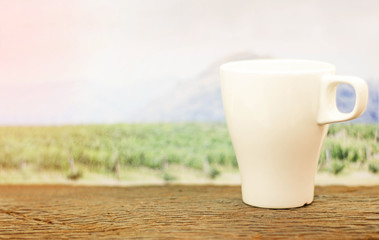 a cup of coffee on wood in the coffee plantation