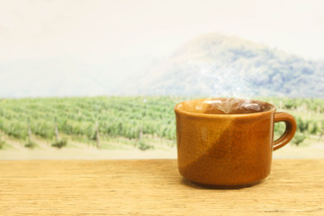 a cup of coffee on wood in the coffee plantation