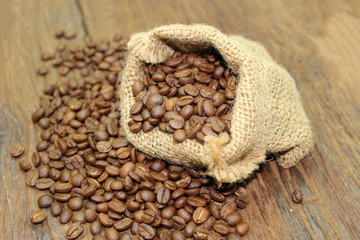 Coffee beans in a sack bag on wood background