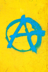 Blaues A für Anarchie auf  Gelbe Wand gemalt