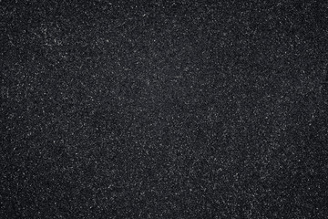 Asphalt texture, black pattern of roadway, grainy surface of pavement. Abstract dark wallpaper.