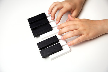 children's hands on the piano keys, toy piano on a white background, piano keys on a white background, music background