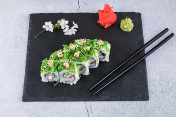 Sushi rolls with seafood and Chuka salad. Green sushi. Top view. Free space for your text.