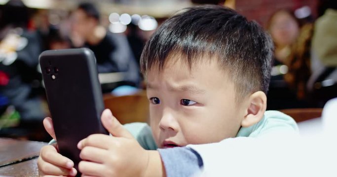 Asian boy watch program on cellular