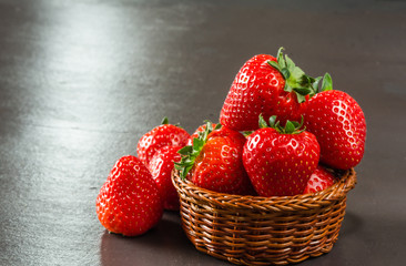 Fresh  delicious strawberries in a basket on table.