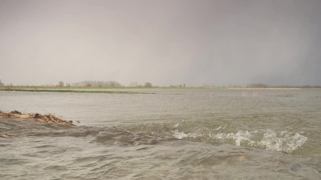 Water running over the floodplains of the river IJssel during flooding caused by high water levels in the river in Overijssel The Netherlands 

