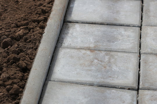 Concrete or cobble gray square pavement slabs or stones for sidewalk, road paving