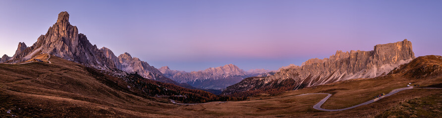 Fototapeta premium Italian Dolomites mountain (Ra Gusela rock in front) peaceful evening dusk panorama from Giau Pass. Picturesque climate, environment and weather concept sky background. Car models unrecognizable.