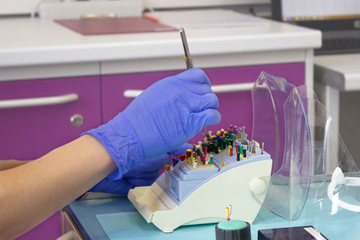 Gloved hand holding endodontic boxes with tools