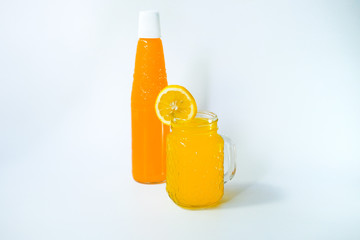 fresh cold drink orange syrup over ice cubes, isolated on a white background. Making orange lemonade. Tropical mocktail.