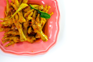 Asian food spicy chicken feet, served with a green plate isolated from a white background