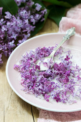 Lilac flowers with sugar, lilac and pink napkin on a wooden background. Rustic style.