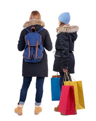 back view of two women with shopping bags in winter jacket.